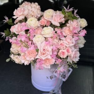 Delicada composición en tonos rosados en una caja