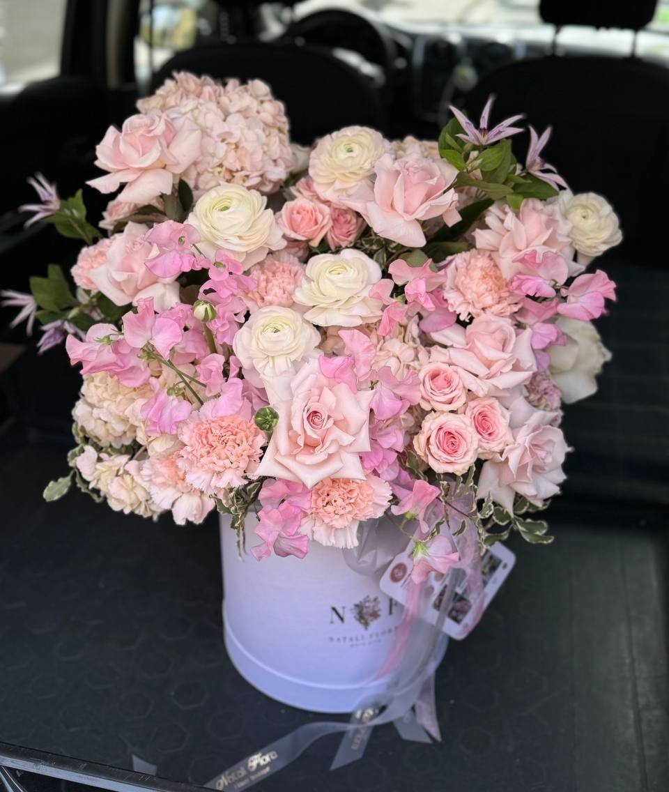 Delicada composición en tonos rosados en una caja